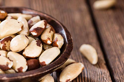 Raw Brazil Nuts unsalted on wooden ground in bowl by Anna and Sarah