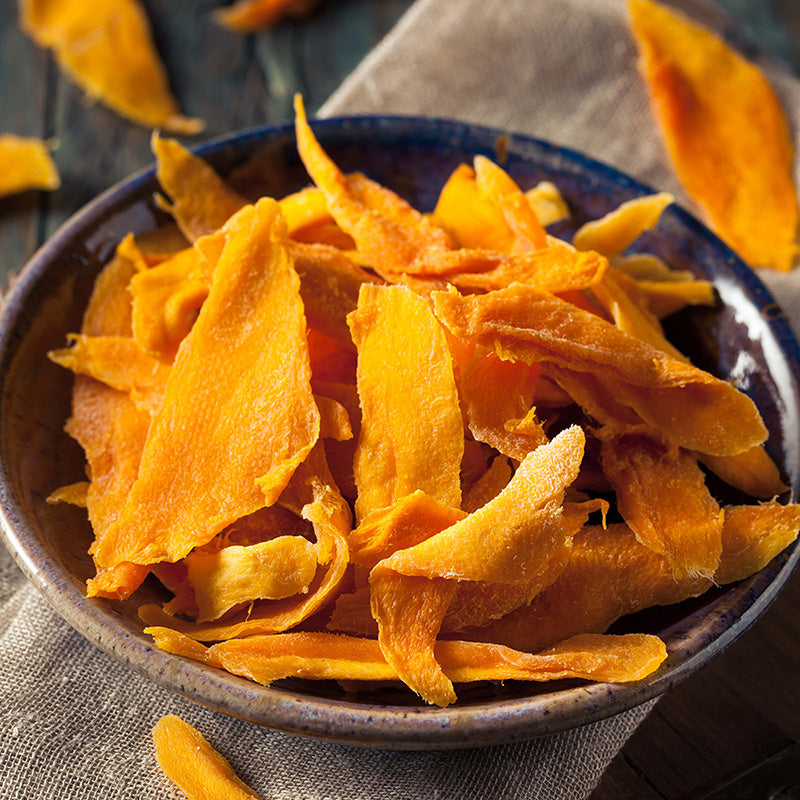 Organic Dried Mango Slices on the wooden table in the grey bowl by Anna and Sarah